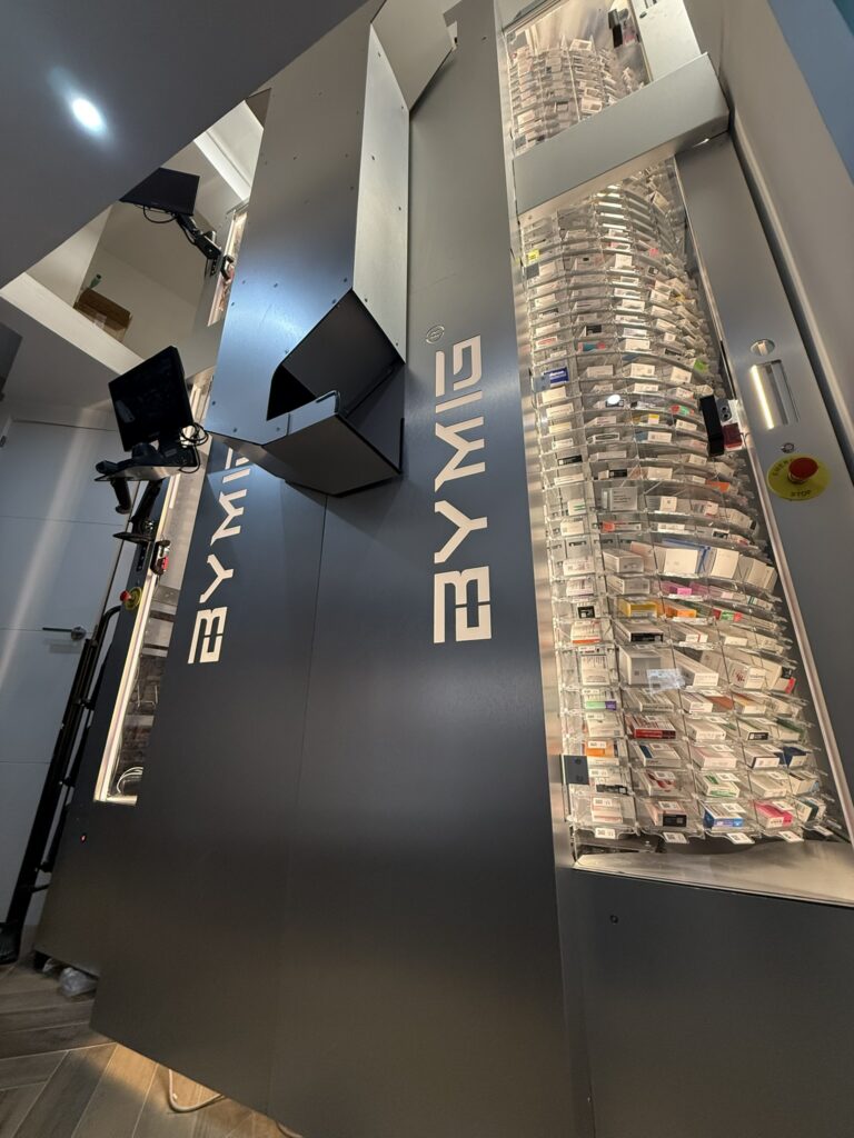 Interior de un robot de farmacia BYMIG con medicamentos almacenados y pantalla de control